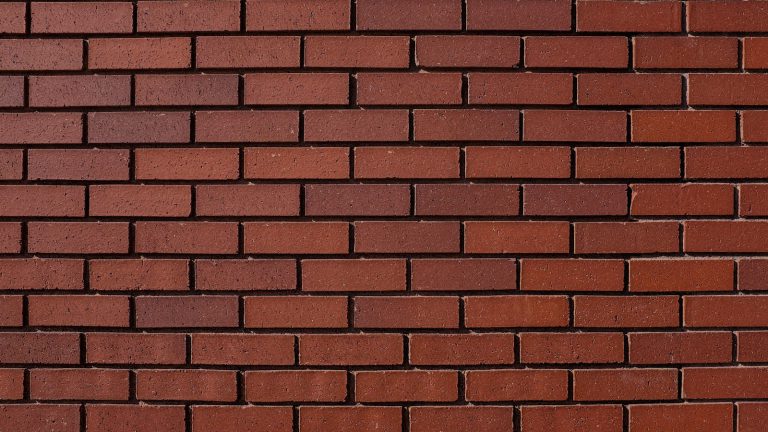 A wall of red bricks with mortar joints