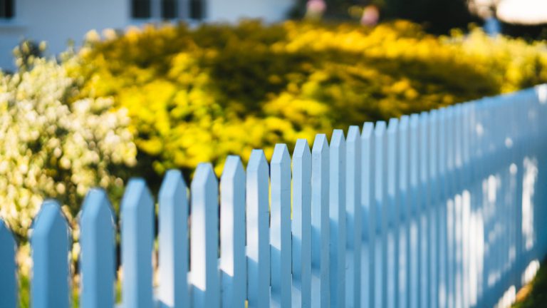 A white picket fence in front of a house