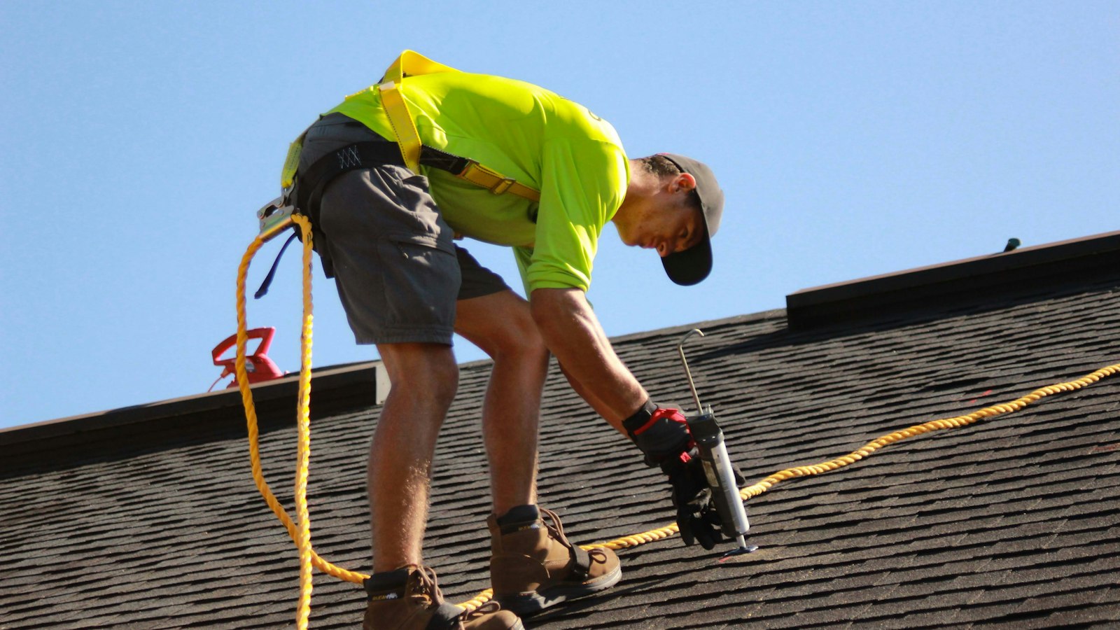 A roofer working on a roof with a power tool