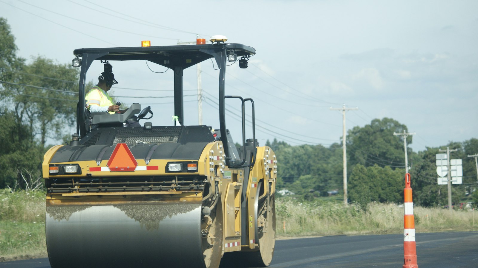 Yellow paving machinery at work on a road