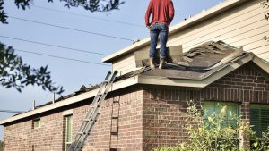 A worker standing on the roof of a house