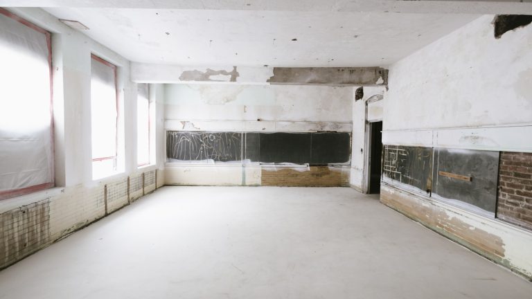 Empty room under renovation with exposed walls and windows