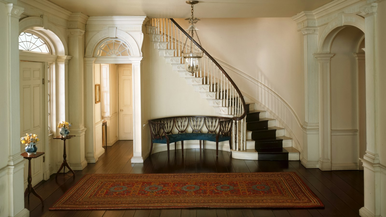 A staircase in a house with a rug at its foot