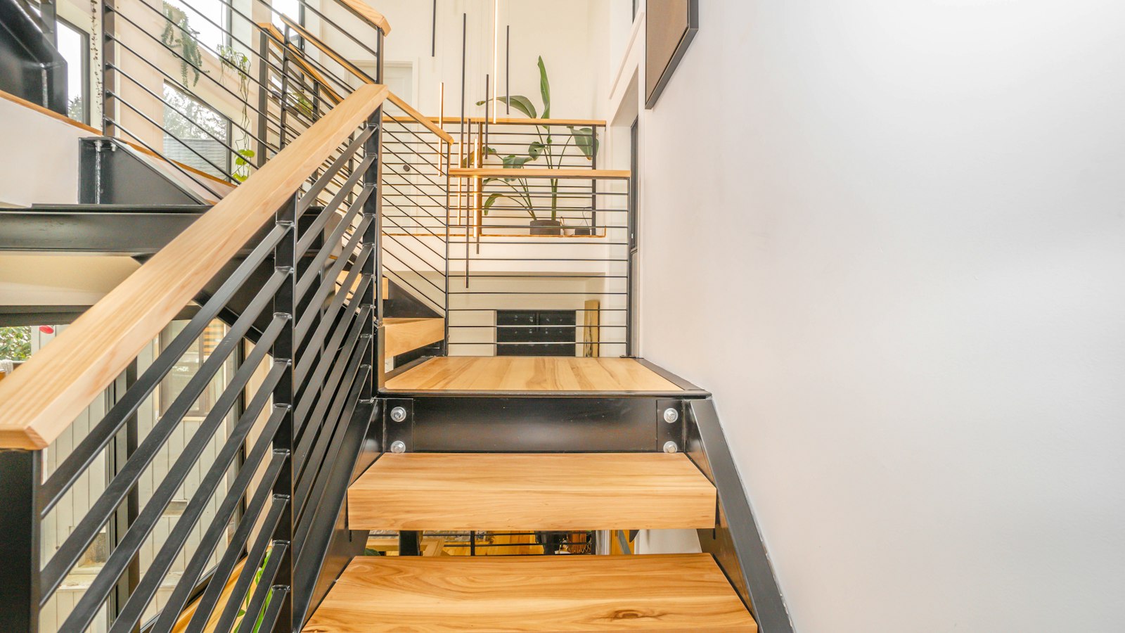 A wooden staircase with stainless steel railings