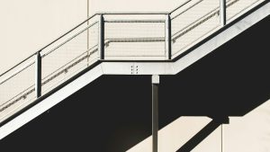 White metal stairs against a concrete wall